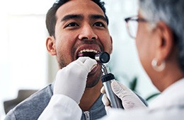 Doctor looking into a man’s mouth