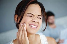 Woman holding cheek in pain