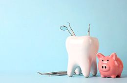 A large model tooth sitting next to a piggy bank