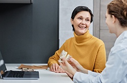 A dentist and patient discussing implant dentures