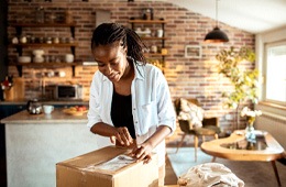 Young woman opening a package
