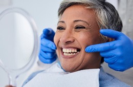 a smiling woman looking in a mirror