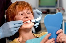 Woman looking at smile in mirror