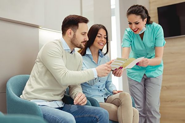 dentist in Campbell showing pamphlet to two patients