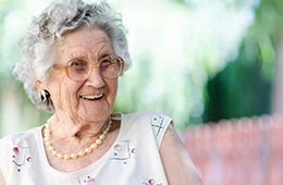 Senior woman with implant dentures laughing outside