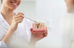 dentist showing a dental implant to a patient