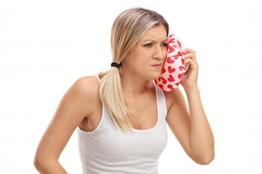 woman holding cold compress to face 