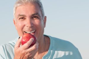 Man with dentures biting an apple